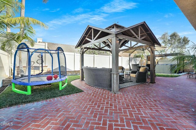 view of patio featuring an outdoor hangout area, a trampoline, and a gazebo