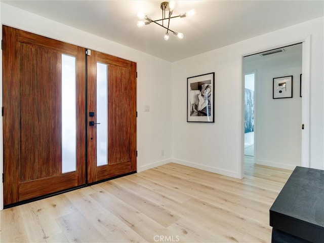 entrance foyer featuring a notable chandelier and light hardwood / wood-style flooring