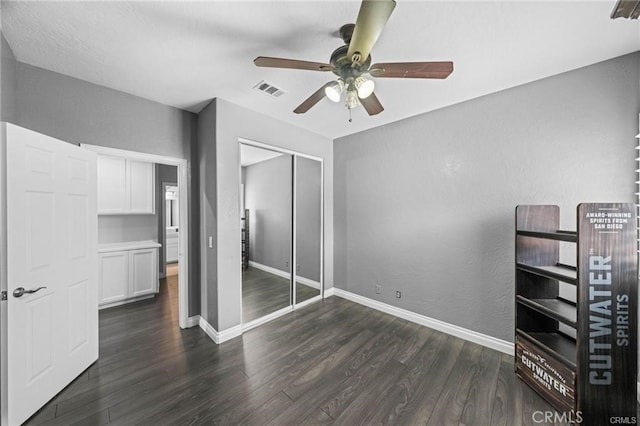 unfurnished bedroom with ceiling fan, a closet, and dark hardwood / wood-style flooring