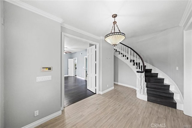 foyer with ceiling fan, ornamental molding, and hardwood / wood-style flooring