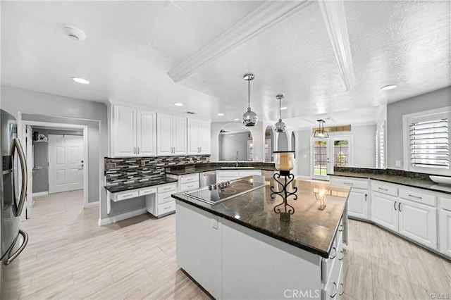 kitchen with hanging light fixtures, kitchen peninsula, white cabinetry, and stainless steel appliances