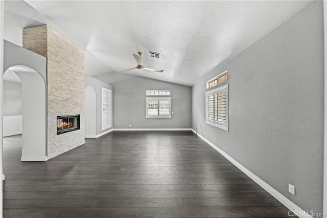 unfurnished living room with ceiling fan, dark wood-type flooring, built in features, and a fireplace