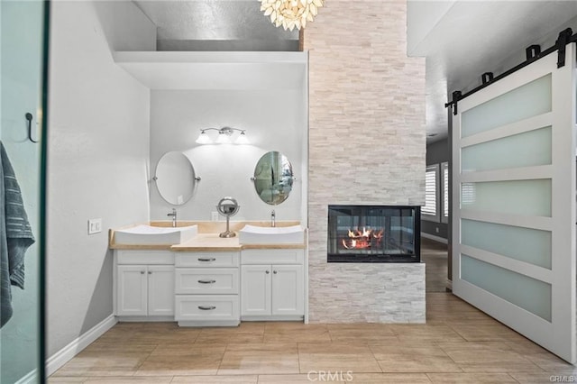 bathroom featuring vanity, a multi sided fireplace, and built in shelves