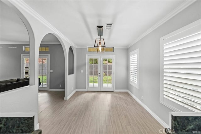 entryway featuring a chandelier, crown molding, and french doors