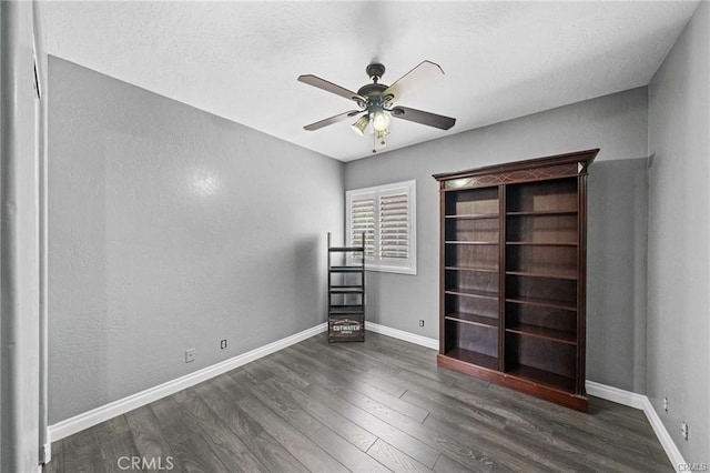 unfurnished bedroom with ceiling fan and dark hardwood / wood-style floors