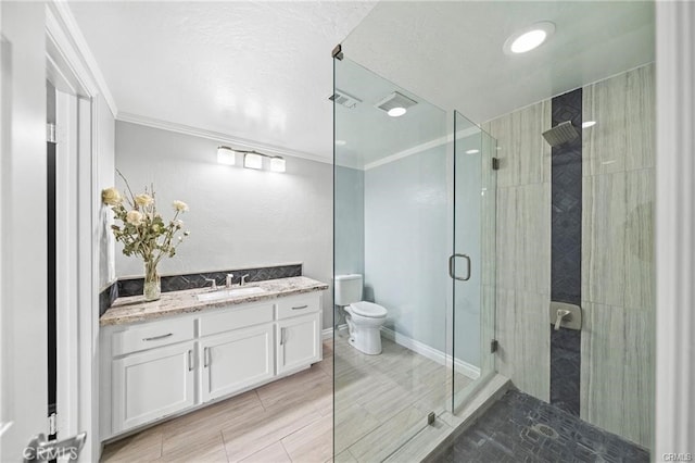 bathroom with toilet, ornamental molding, walk in shower, and vanity