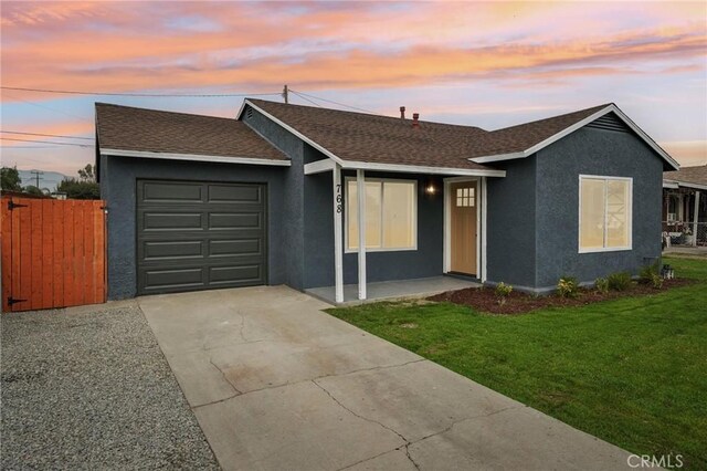 single story home with a garage and a lawn