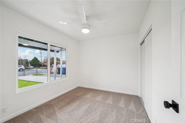 empty room featuring light carpet and ceiling fan