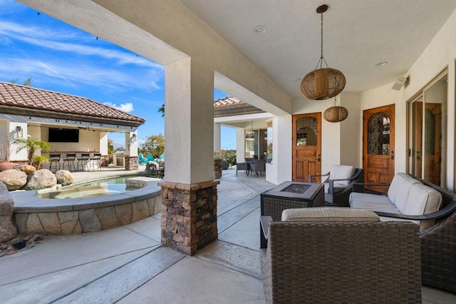 view of patio / terrace featuring a pool with hot tub, an outdoor fire pit, and exterior bar