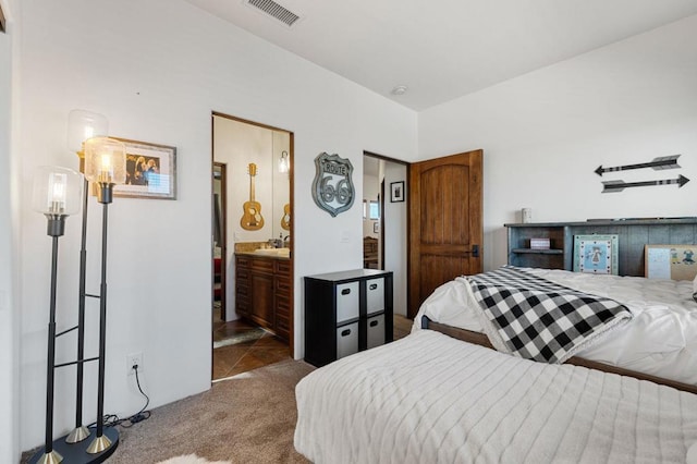 bedroom featuring carpet floors, sink, and connected bathroom