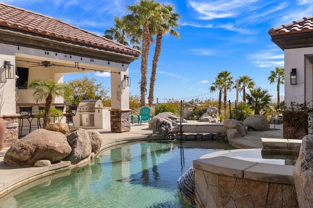 view of pool with ceiling fan, a patio area, and area for grilling