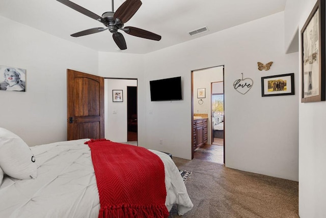 carpeted bedroom featuring ceiling fan and ensuite bath