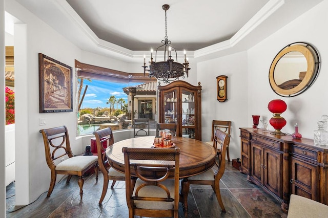 dining space featuring a chandelier and a raised ceiling