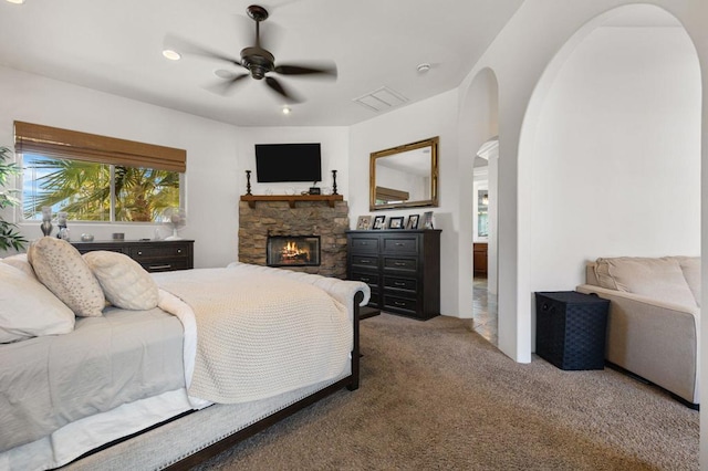 bedroom featuring ceiling fan, a fireplace, and carpet floors