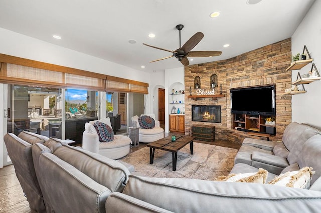 living room featuring ceiling fan, built in features, and a fireplace