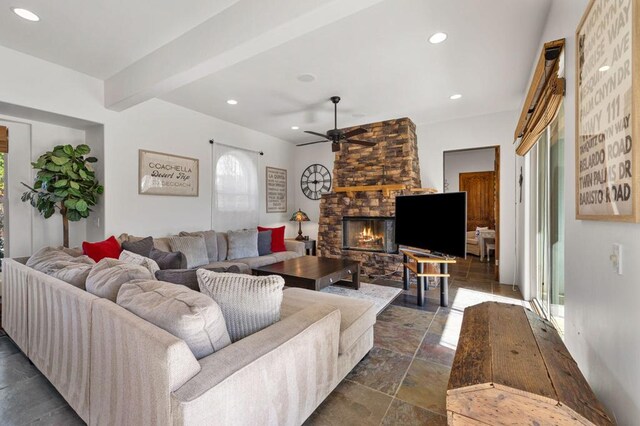 living room with ceiling fan, a fireplace, and beamed ceiling