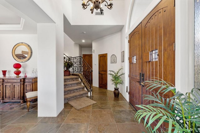 foyer entrance with a high ceiling and a notable chandelier