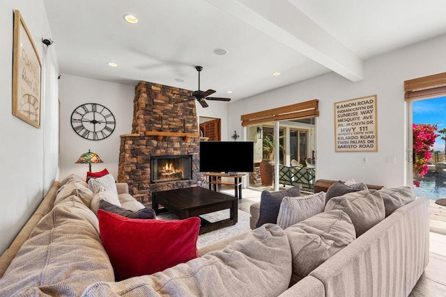 living room featuring ceiling fan, a fireplace, and beamed ceiling