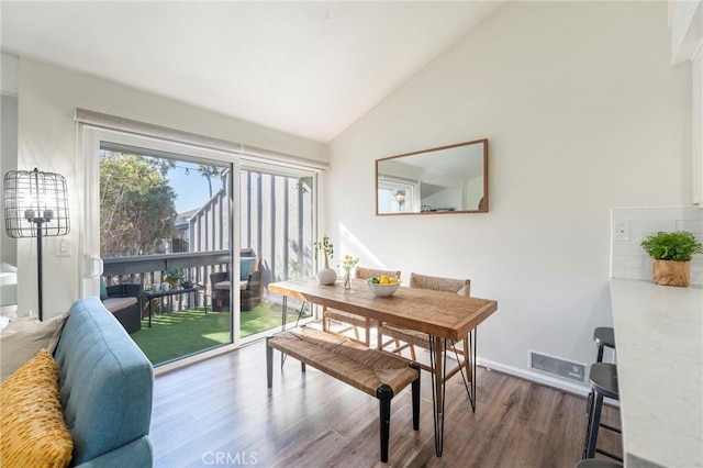 dining area with lofted ceiling and hardwood / wood-style flooring