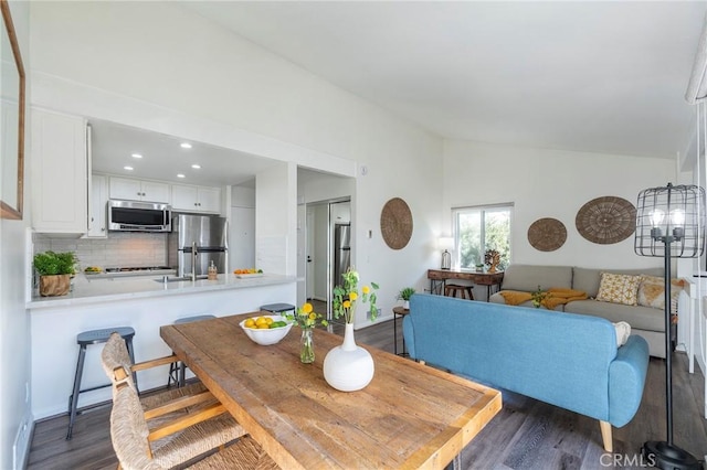 dining space with lofted ceiling and dark hardwood / wood-style flooring