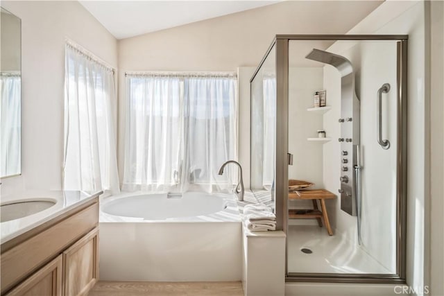 bathroom featuring vanity, lofted ceiling, and shower with separate bathtub