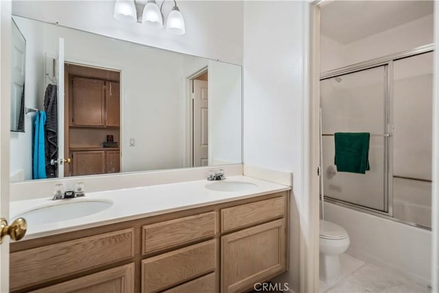 full bathroom featuring shower / bath combination with glass door, vanity, toilet, and tile patterned flooring