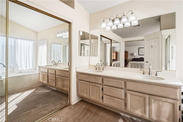 bathroom with lofted ceiling, vanity, and a bath