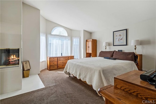 bedroom featuring light colored carpet and vaulted ceiling