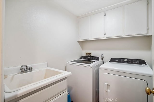 clothes washing area featuring cabinets, sink, and washing machine and dryer