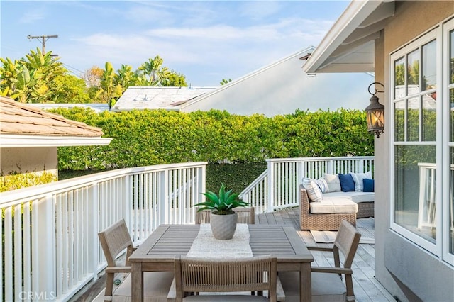 wooden balcony with an outdoor living space and a wooden deck