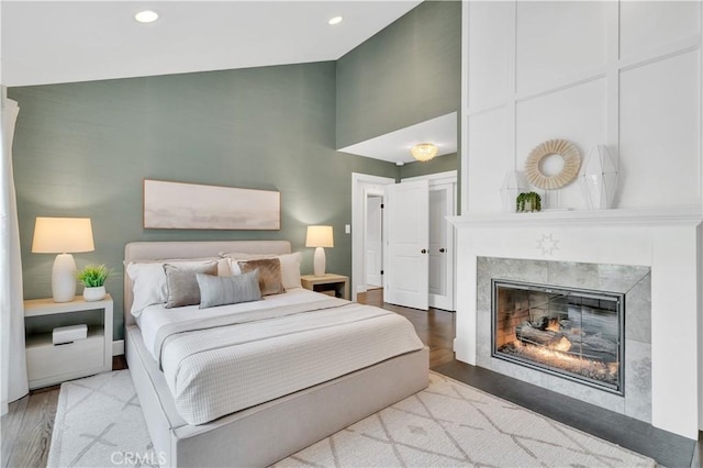 bedroom featuring light hardwood / wood-style floors and a tile fireplace