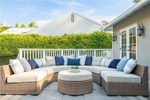 wooden deck with an outdoor living space and french doors