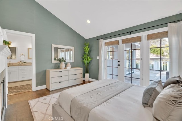 bedroom with ensuite bathroom, access to exterior, light wood-type flooring, high vaulted ceiling, and french doors