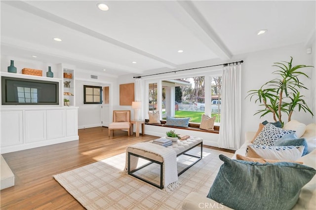 living room featuring light wood-type flooring and beamed ceiling