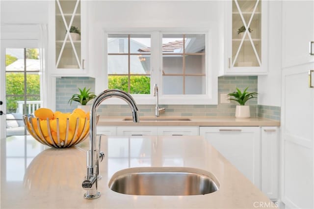 kitchen featuring plenty of natural light, white cabinets, and tasteful backsplash