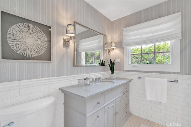 bathroom with toilet, tile walls, tile patterned floors, and vanity