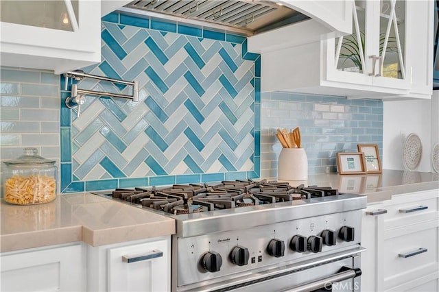 kitchen with white cabinetry, wall chimney exhaust hood, gas stove, and tasteful backsplash