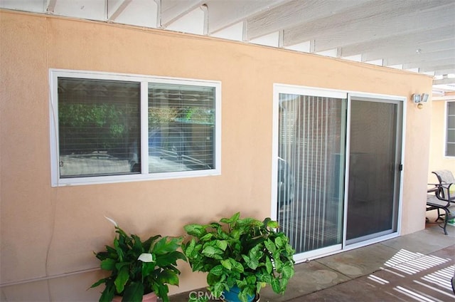 view of exterior entry with a patio