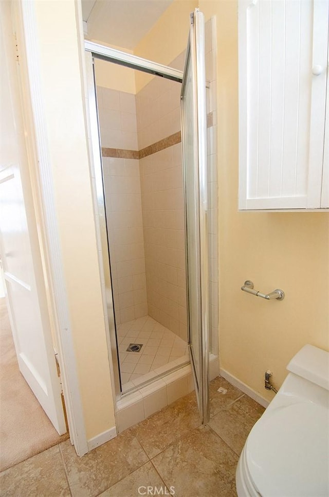 bathroom with toilet and a shower with door