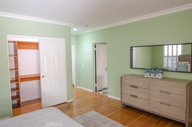 bedroom with crown molding and light hardwood / wood-style floors