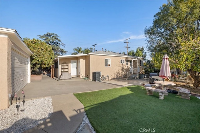 rear view of house featuring central AC unit, a patio, and a yard