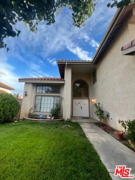 entrance to property with a lawn