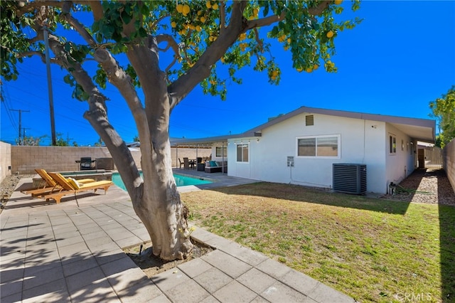 exterior space featuring a fenced in pool, a patio area, cooling unit, and a lawn