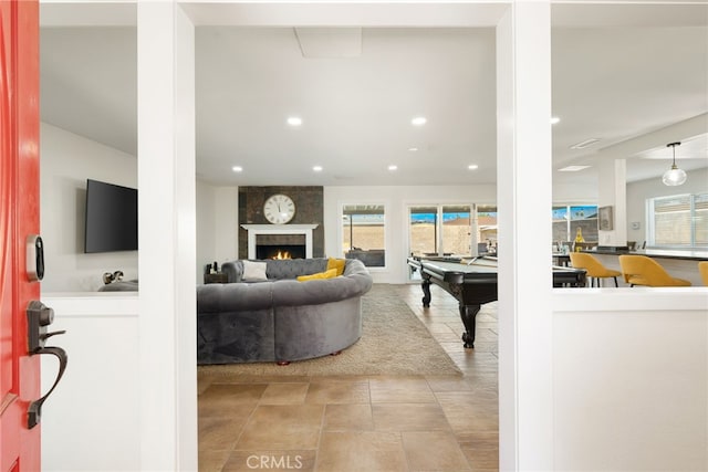 living room featuring billiards, a fireplace, and light tile patterned flooring