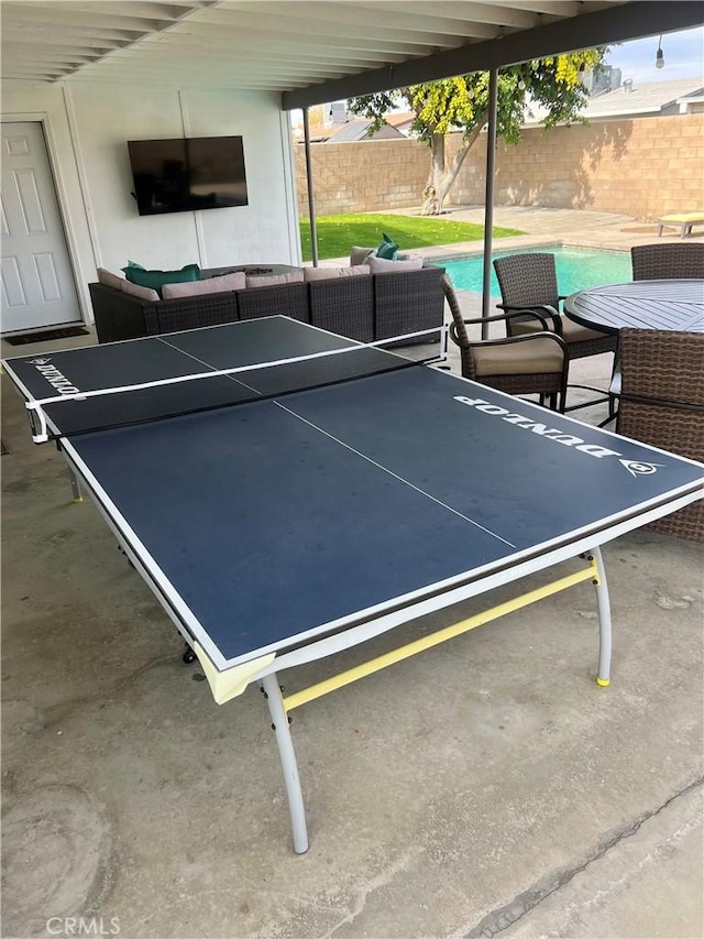 view of sport court featuring a fenced in pool, an outdoor living space, and a patio