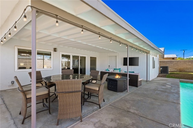 view of patio with central AC unit and a fire pit