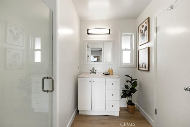 bathroom featuring a shower with shower door, vanity, and hardwood / wood-style flooring