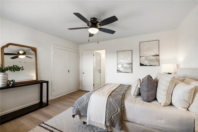 bedroom with ceiling fan, light hardwood / wood-style flooring, and a closet