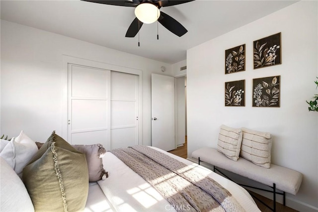 bedroom with ceiling fan, a closet, and wood-type flooring