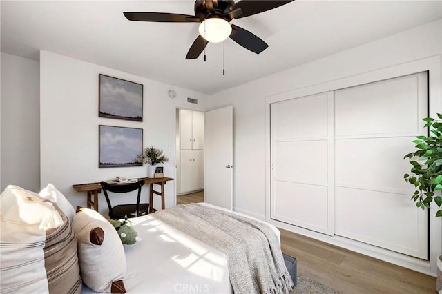 bedroom with ceiling fan, a closet, and hardwood / wood-style floors